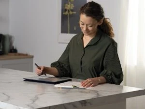 Woman in the kitchen with HP Elite Dragonfly laptop. Keywords: remote work, remote working, work from home, working at home, home office