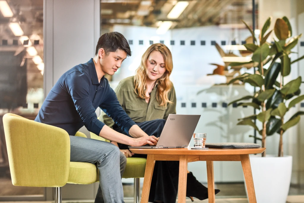 Man and women interacting with a Lenovo Yoga laptop.