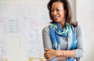 A businesswoman standing and smiling in boardroom.