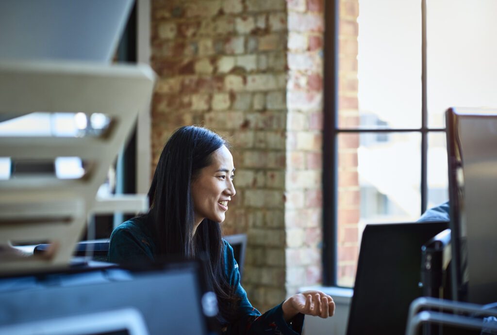 Photo of a Dynamics 365 finance and operations customer sitting at a desk using a laptop computer.