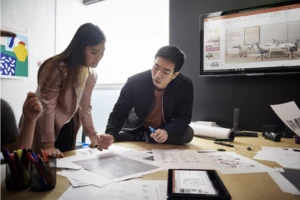 Business professionals collaborating at a desk to create engaging customer experiences