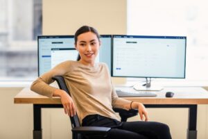 Engineer working at her desk; multi-screen workstation.