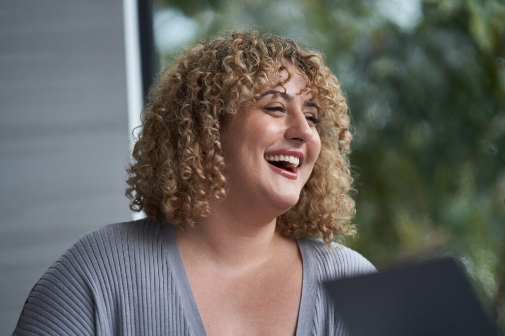 Close-up of woman looking to the side, smiling.