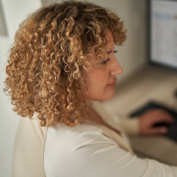 A close-up of a woman focused on her computer screen.