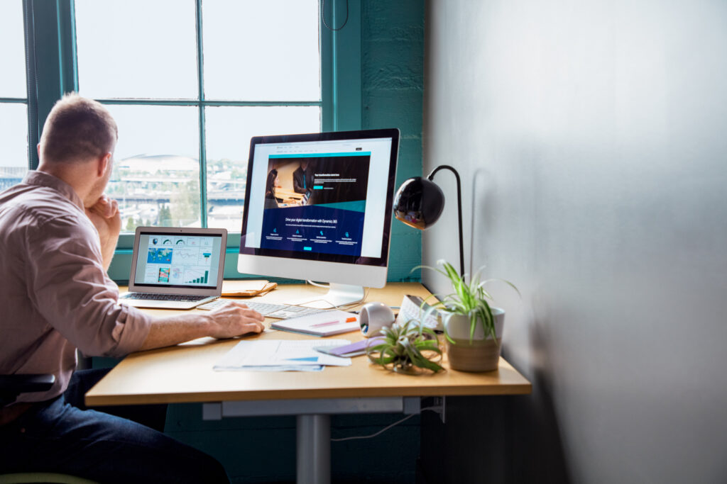 a person sitting at a table using a laptop computer