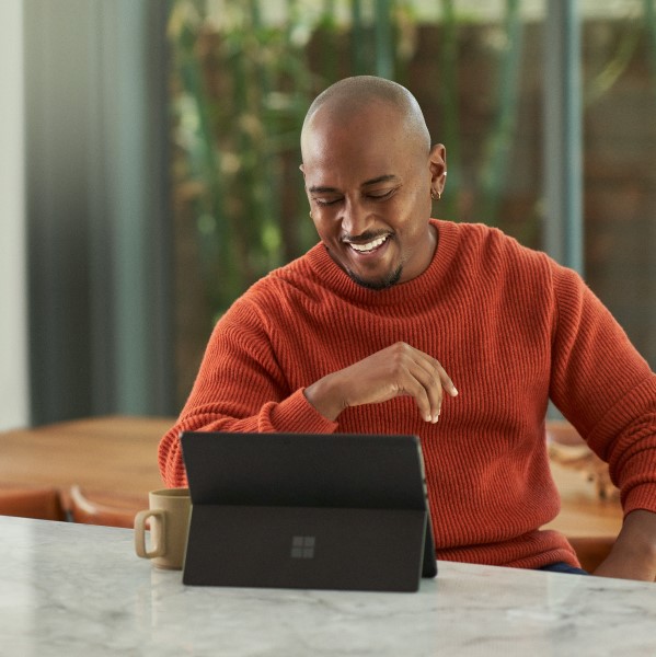 a person sitting at a table using a laptop