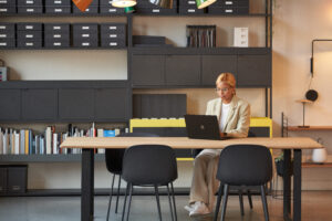 Retail store manager working on a laptop in an office space