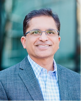 A man wearing glasses and a suit