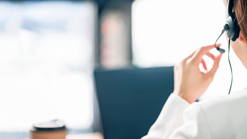 Call center help line service. Rear view of female operator in h