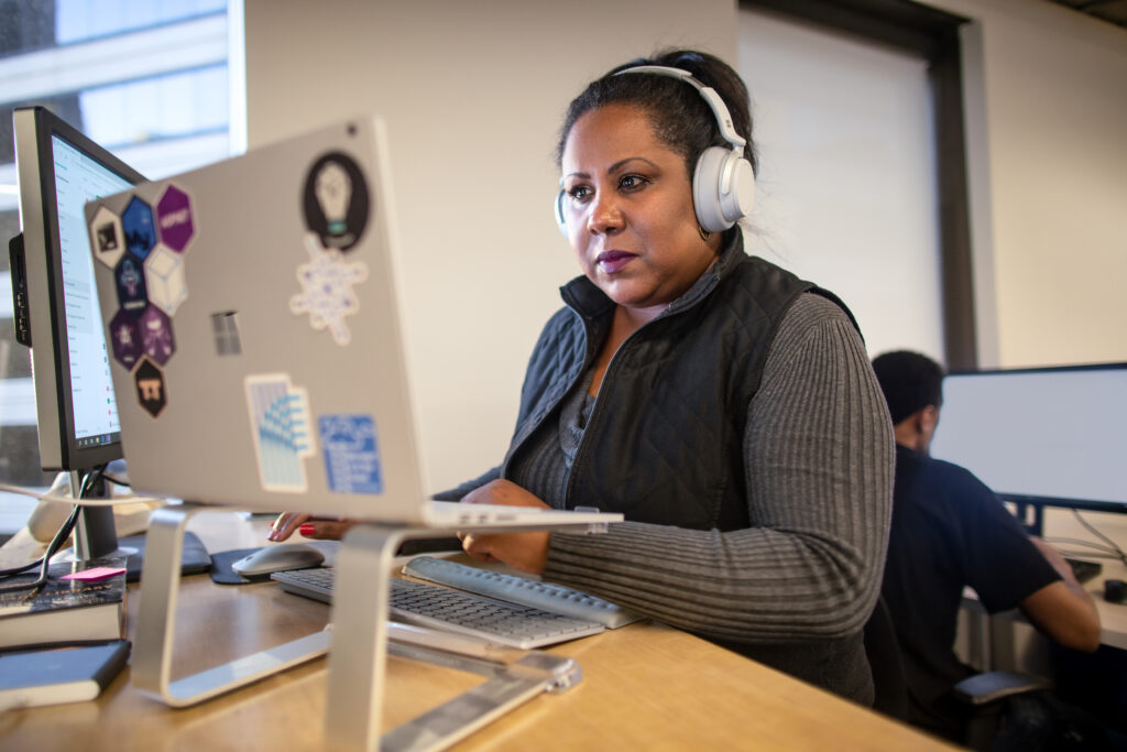 A cybersecurity professional working on a laptop in an office setting.  