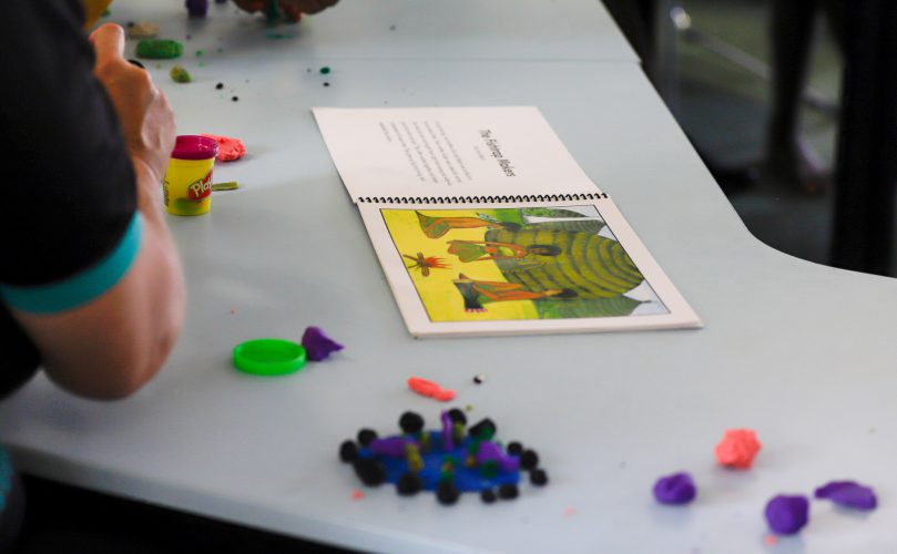 A student models a character from an indigenous storybook using modeling clay.