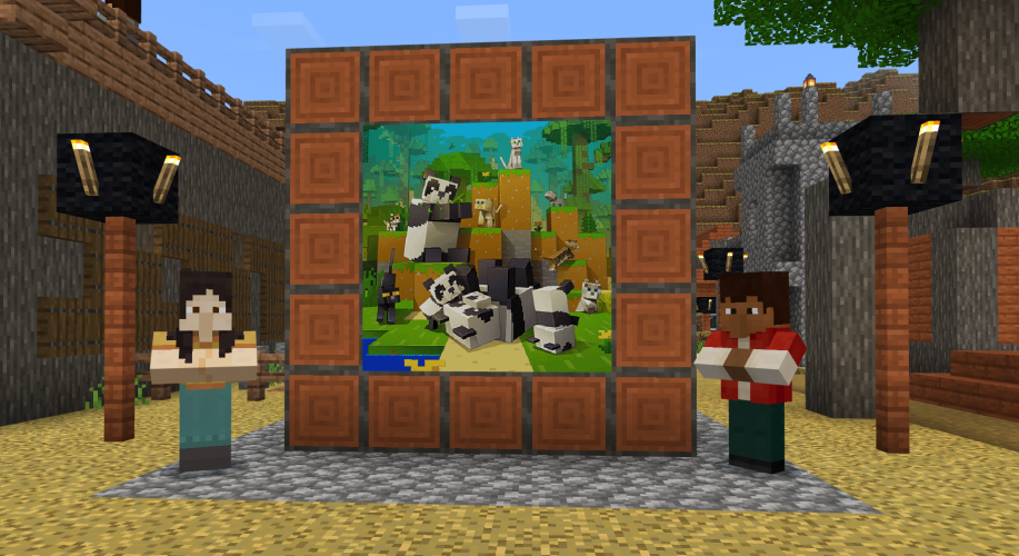 Two people stand in front of a mural featuring pandas and cats in Minecraft: Education Edition