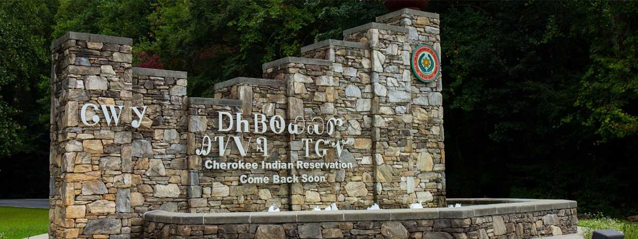A stonework welcome sign for the Eastern Band of Cherokee Indians’ reservation in Cherokee, North Carolina. The sign is written using both the Cherokee syllabary as well as the English translation which reads ‘Cherokee Indian Reservation / Come Back Soon.