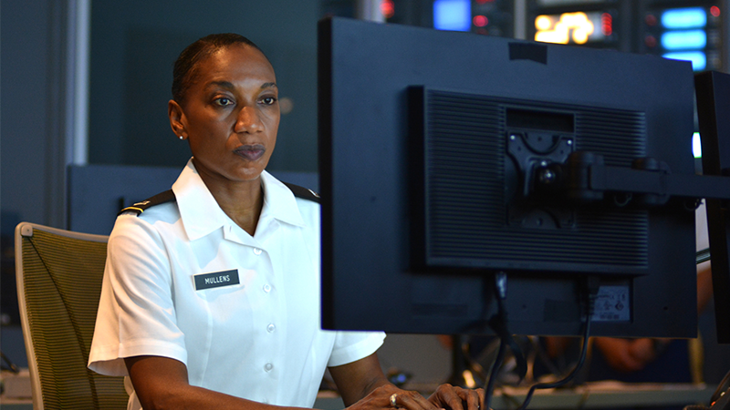 female military personnel member working at a computer monitor