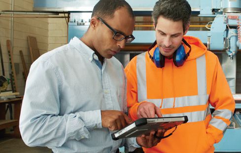 2 men using a tablet in a manufacturing facility