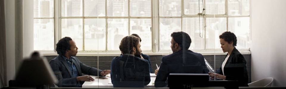 Two people in meeting room talking.