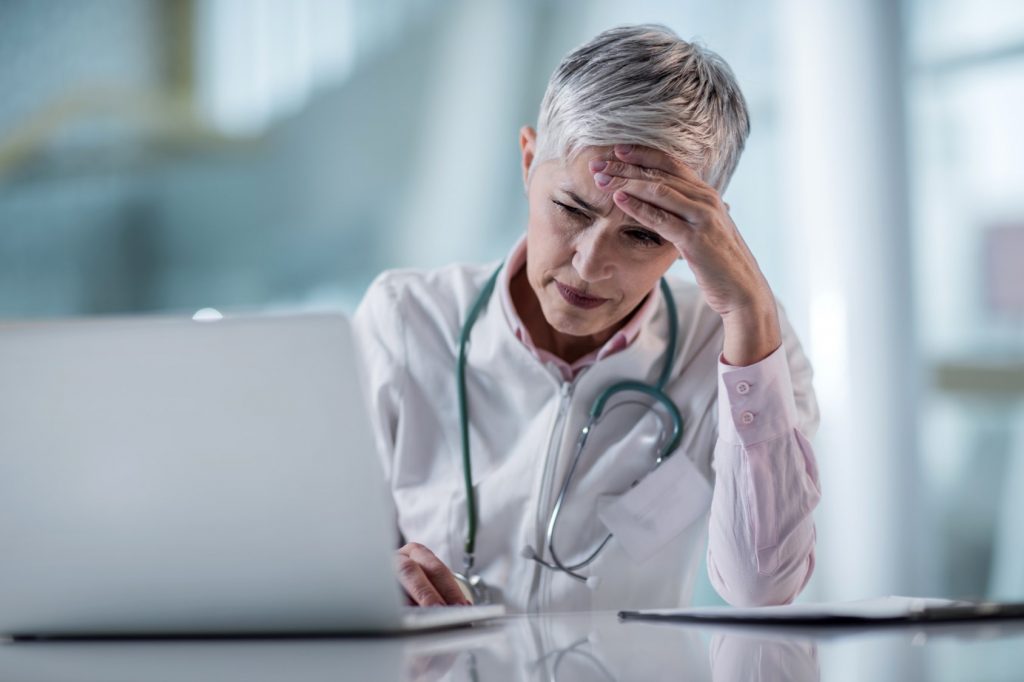 An image of a doctor looking exhausted.