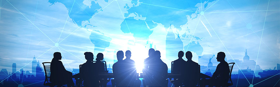 Header image: people at a conference table overlayed with an image of a world map.