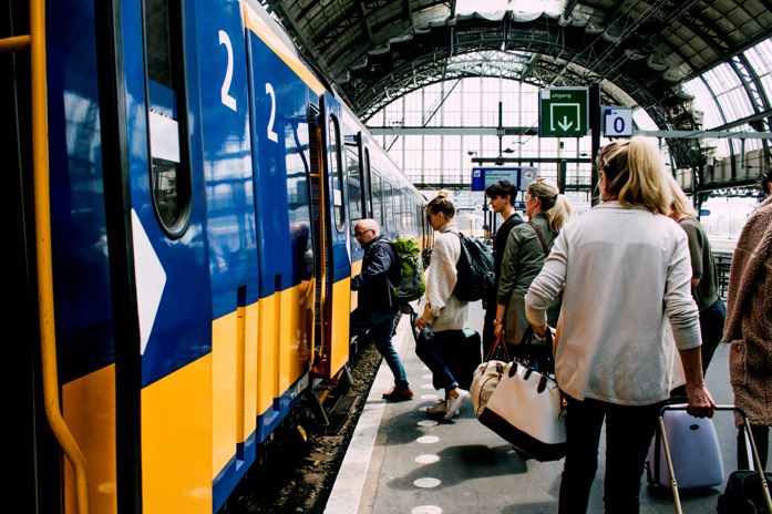 An image of a train station and people boarding a train.