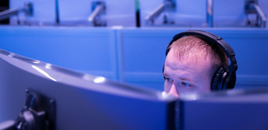 A man with headphones working on a computer.