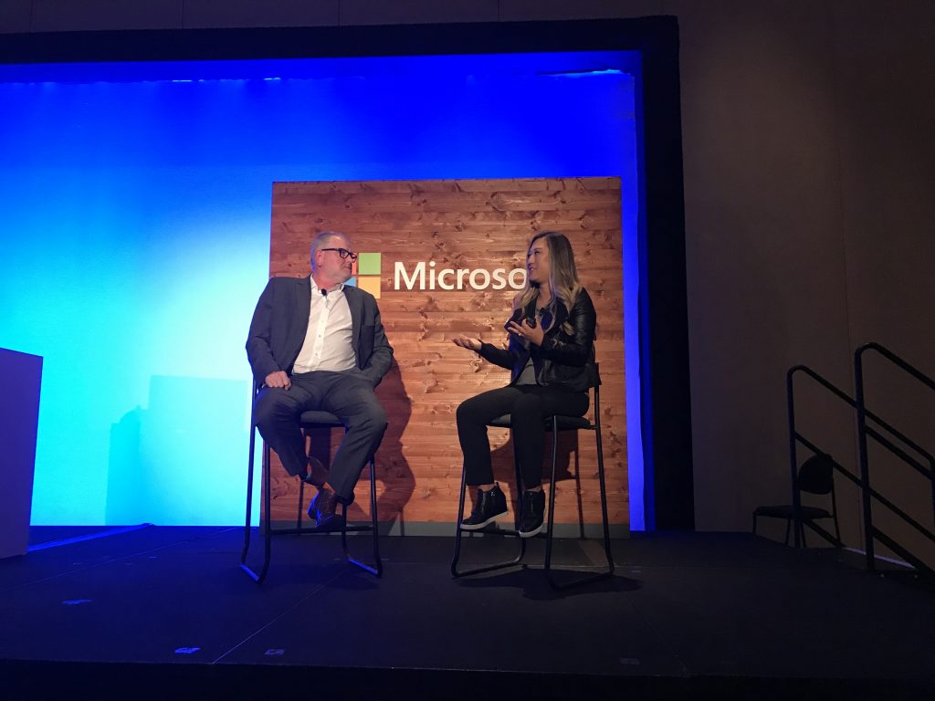 Two people sitting on a Microsoft stage conducting an interview