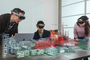 Three people building out a model of a city using virtual reality