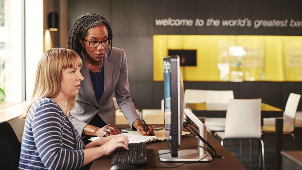 Two women working on a device