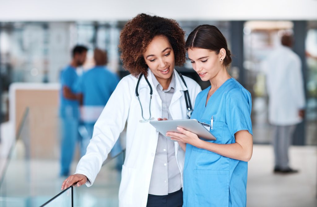 Two doctors in hospital analyzing tablet