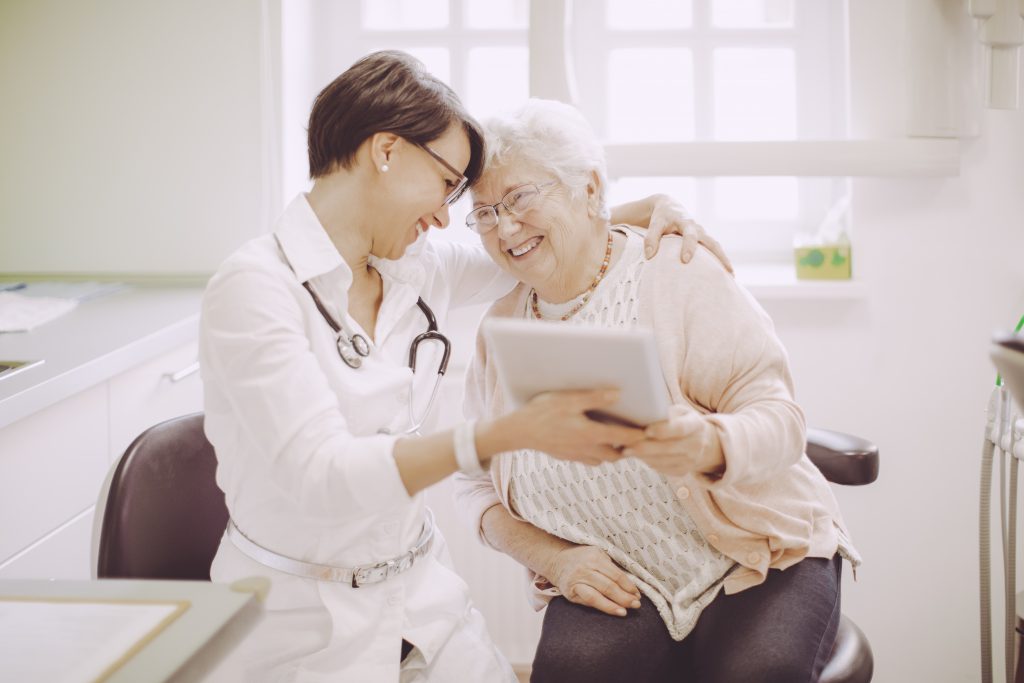 Senior woman at the doctor reviewing tablet