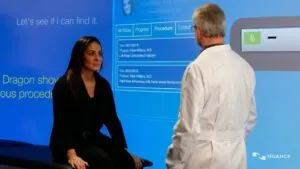 Man talking to a woman in front of a large data screen