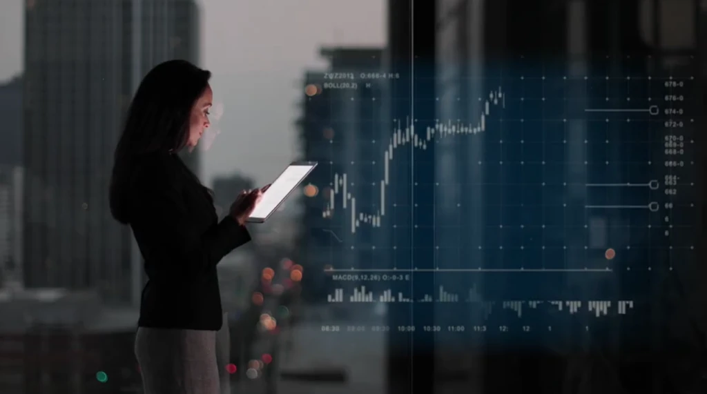 photo of woman looking at a tablet standing in front of a window