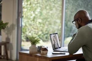 a person sitting at a table in front of a window