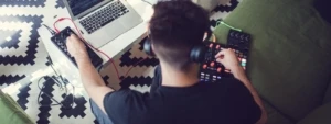 person wearing headphones sitting at a laptop
