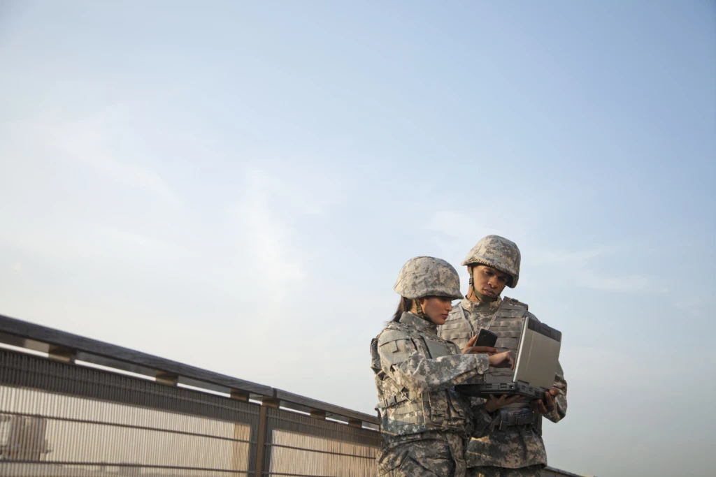 Two soldiers using laptop computer