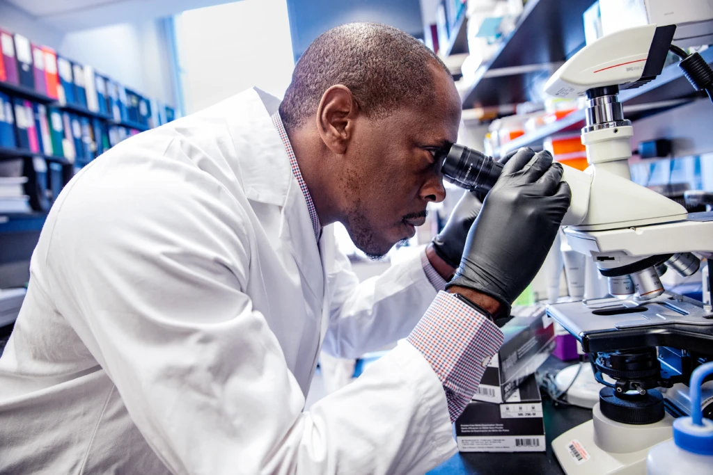 medical professional looking through a microscope