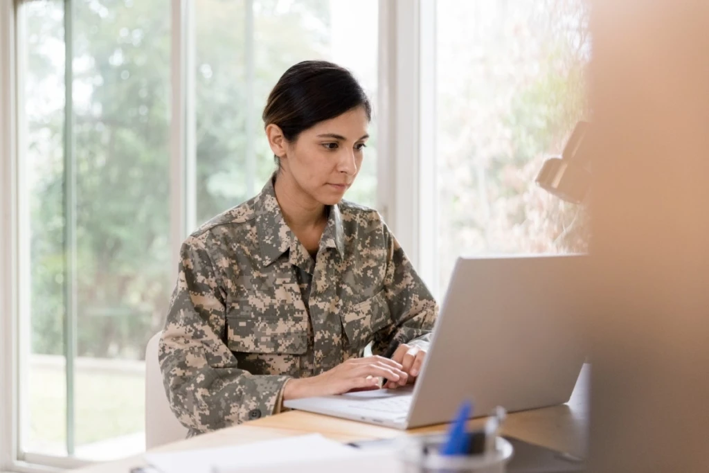 a person sitting at a table using a laptop