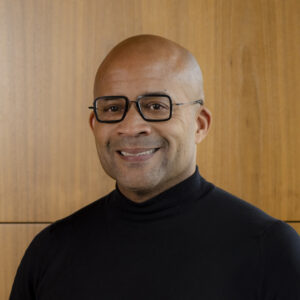 A man wearing glasses smiling at the camera