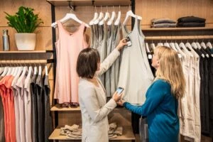 Two people in a store looking at clothing.