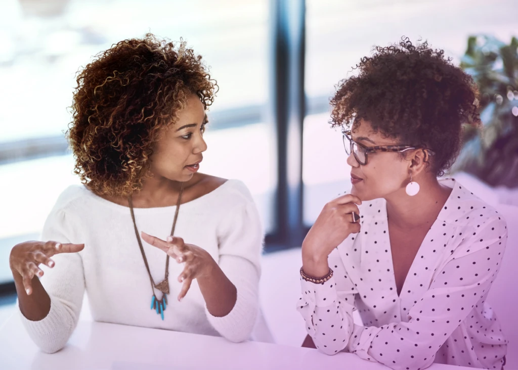 Two people in discussion, working in a modern office.