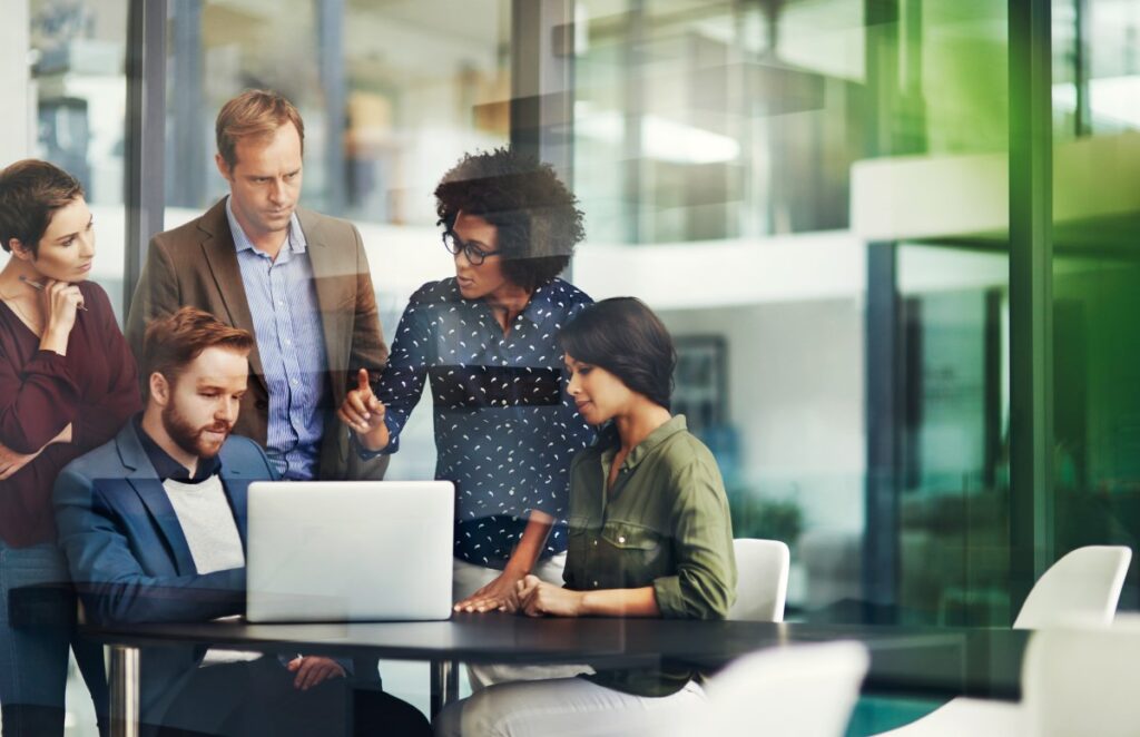 A group of people discussing over the content on a laptop screen