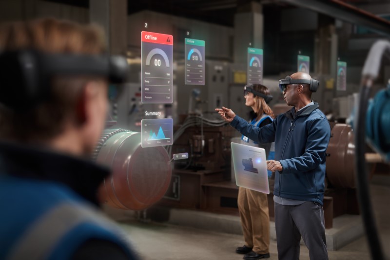 Two men and a woman collaborating using Microsoft Hololens 2 on the manufacturing floor.