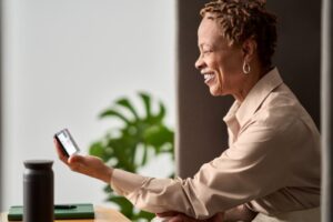 Woman smiles as she looks at her smartphone