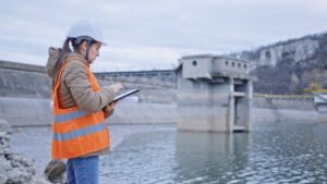 Female engineer working in hydroelectric dam. Ecology orientated. Renewable energy systems