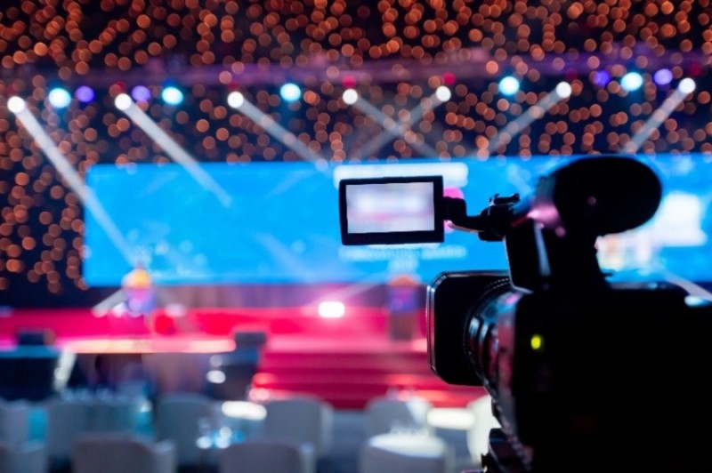 Video camera operator working with his equipment at indoor event