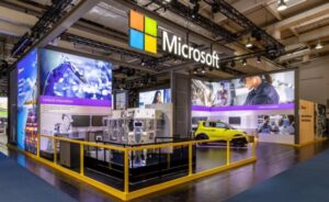Side view of the Microsoft booth at Hannover Messe fair at Hannover Germany, April 17-22, 2023. Industrial equipment, robot and an electric vehicle are visible from this side of the booth.