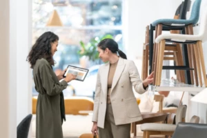 A retail store associate helping a customer by searching for inventory on her shared device.