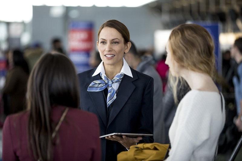 Frontline worker assisting customers using tablet.
