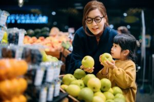 Mother and daughter selecting produce in a grocery store