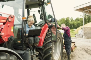 Woman using laptop on tractor