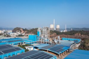 Solar power plant on factory roof under blue sky